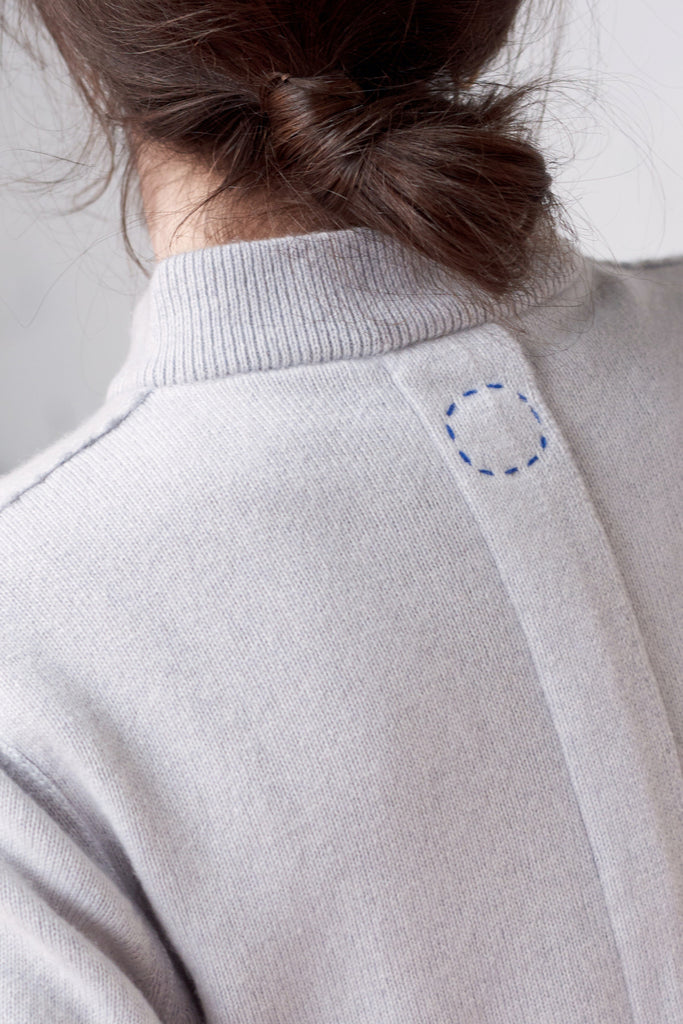 Sphere One cashmere hand knit logo circle of stitches on back of original design cardigan