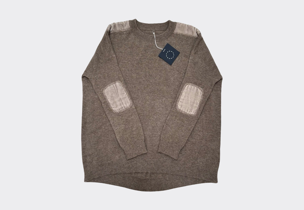 Light brown coloured long sleeve round neck cashmere sweater with velvet elbow and shoulder patches on a light gray background
