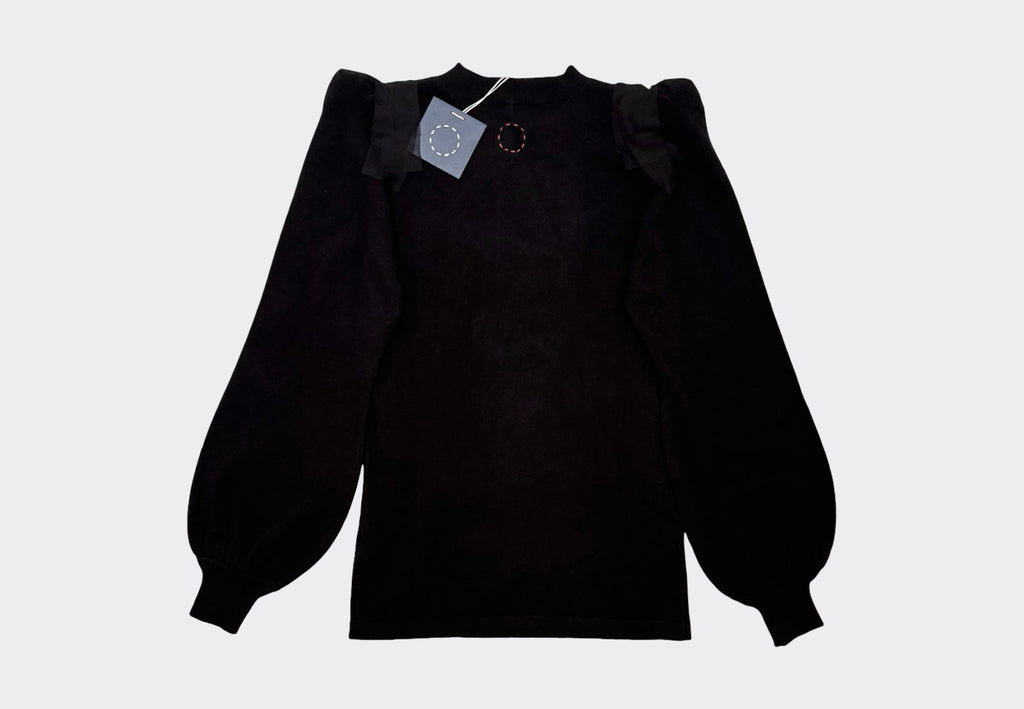 Black cashmere sweater with balloon sleeves on a light gray background