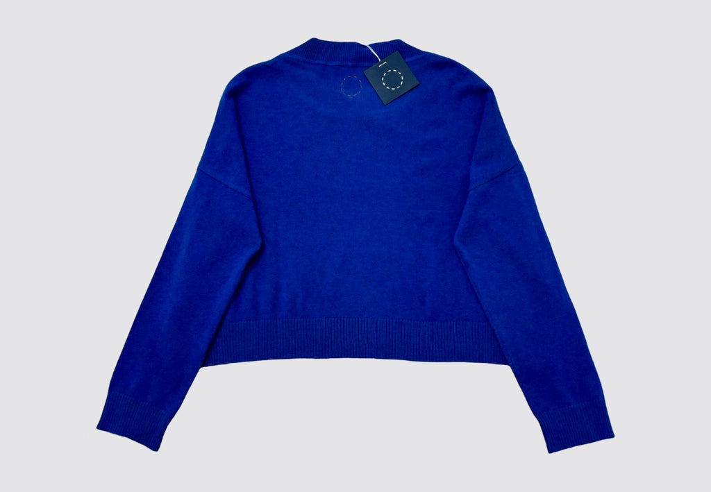 Back product flat lay image of yellow cropped round neck cashmere sweater with swing tag visible and circle of stitches logo from Irish knitwear brand Sphere One