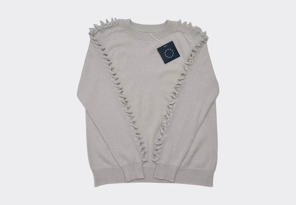 Front product shot round neck pale neutral cashmere sweater with raised cashmere stitch on shoulders down the length of the arms.