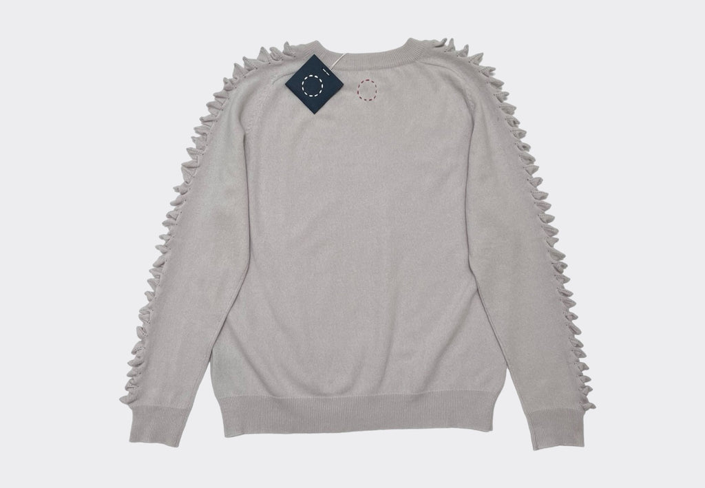 Back product shot round neck pale neutral cashmere sweater with raised cashmere stitch on shoulders down the length of the arms.
