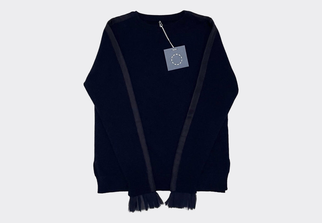 Front product shot navy cashmere Sphere One Rufflecuff sweater with navy chiffon and grosgrain arm and cuff detail. Navy swing tag with white circle of stitches logo visible 