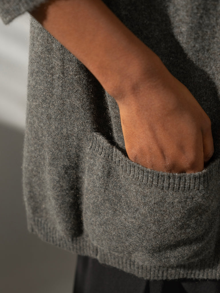 Image of woman's hand in pocket of knitted grey cardigan Sphere One cashmere